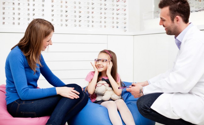 Mother visits optician, optometrist with child